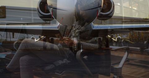 Modern Traveler Reflecting at Airport Lounge Next to Private Jet