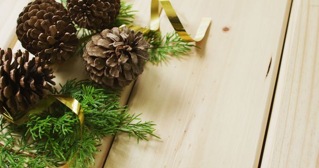 Perfect for holiday greeting cards, festive backgrounds, and seasonal marketing materials. The combination of natural elements and rustic wooden background offers a warm, inviting feel suitable for winter and Christmas themes.