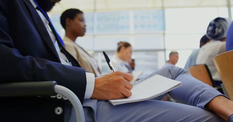 Business Professionals Attentively Writing During Seminar