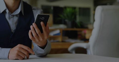 Professional Businessman Using Smartphone in Modern Workspace