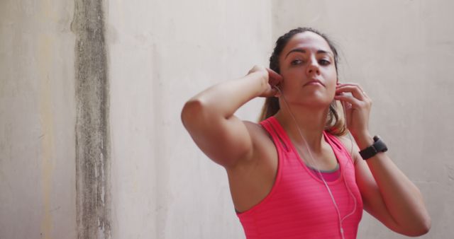 Young Woman Preparing for Outdoor Workout with Earphones - Download Free Stock Images Pikwizard.com