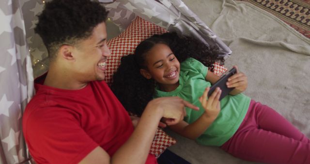 Happy biracial father and daughter using smartphone together - Download Free Stock Photos Pikwizard.com