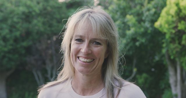 Smiling Middle-Aged Woman in Garden with Natural Greenery - Download Free Stock Images Pikwizard.com