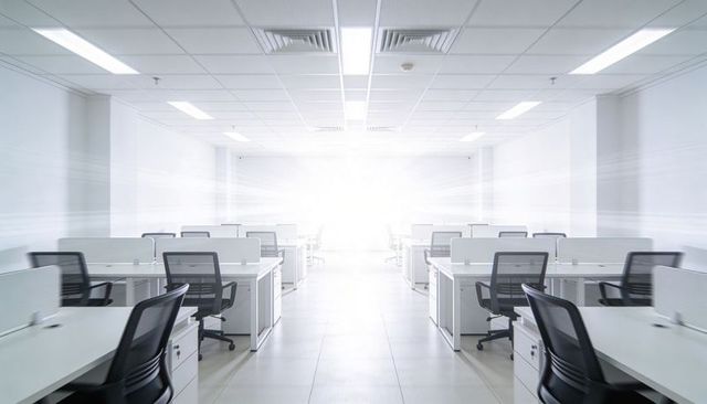 Featuring open-plan workspaces with white desks and black mesh chairs in minimalist office