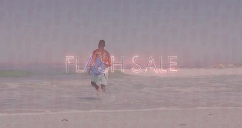 Surfer running into waves with flash sale text on beach