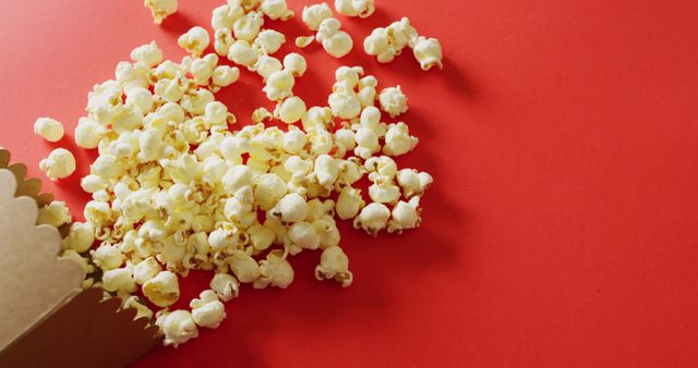 Close-Up of Popcorn Spilled on Vibrant Red Background - Download Free Stock Images Pikwizard.com