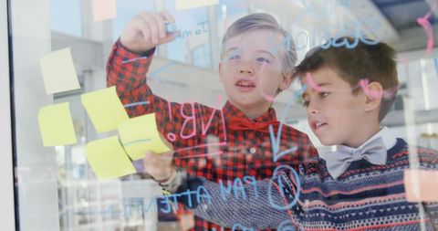 Creative Brainstorming Session by Young Boys Writing on Glass