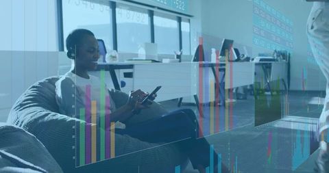 Office workers analyzing virtual data on beanbags in modern workspace