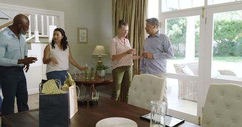 Senior Friends Celebrating with Drinks and Laughter in Cozy Living Room