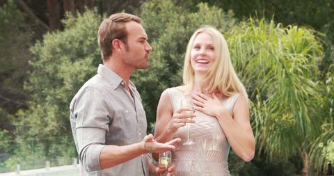 Joyful couple conversing outdoors with wine