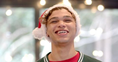 Joyful young man in santa hat celebrating christmas season