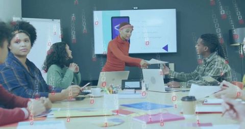 Leading team presentation handing document to colleague during digital strategy meeting
