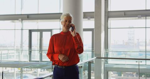 Senior businesswoman discussing on mobile phone in modern office
