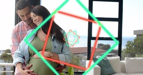 Expectant couple embracing on balcony with ocean view and neon geometric overlays