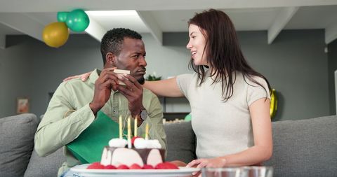Happy Couple Embracing with Birthday Gift in Living Room