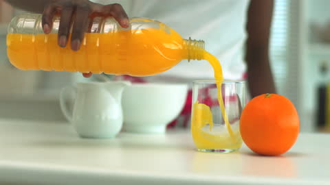 Fresh Orange Juice Being Poured into Glass at breakfast