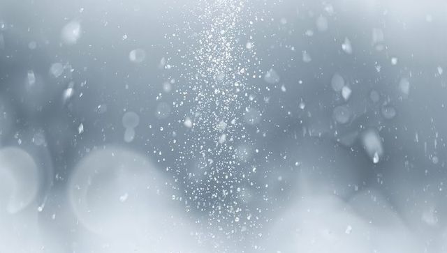 Vertical falling snow column with bokeh and ice crystals soft blue winter texture