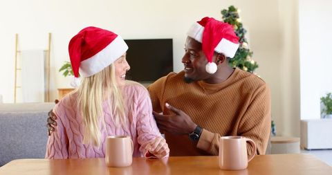 Happy couple embracing holiday spirit with festive mugs