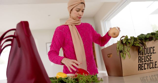 Woman is unpacking fresh vegetables from a reusable grocery bag in a modern kitchen, promoting eco-friendly lifestyle and sustainability. Suitable for wellness blogs, eco-friendly product advertisements, or grocery delivery service promotions.