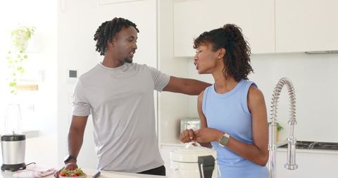 African american couple preparing healthy meal on kitchen island with blender, rice cooker