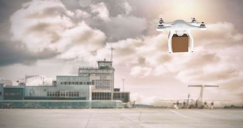 White drone delivering package at airport runway