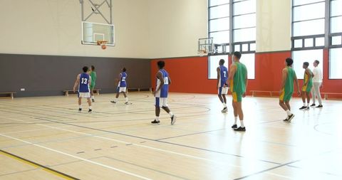 Diverse Basketball Players Competing in Indoor Court