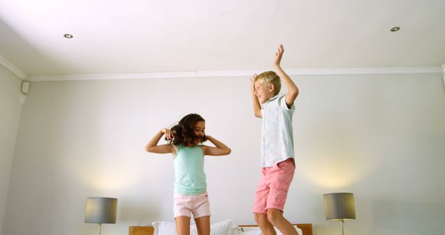 Happy Kids Jumping on Bed in Bright Modern Bedroom - Download Free Stock Images Pikwizard.com