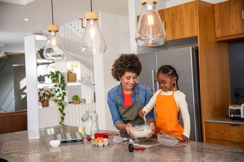 Mother and Young Daughter Baking Together in Modern Kitchen