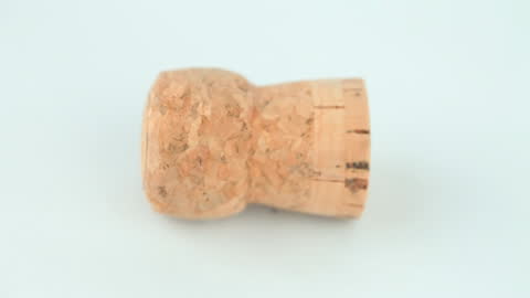 Rotating Champagne Cork on White Surface Background