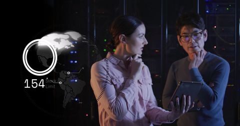 Tech professionals analyzing network data in dark server room