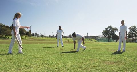 Female Cricketers Practicing Outdoors on Sunny Field