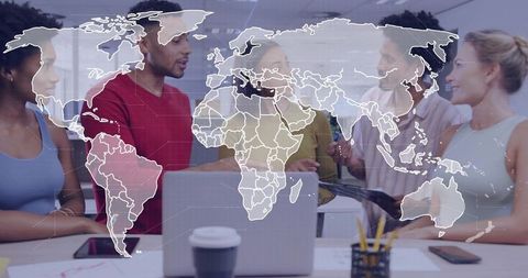 Global team collaborating around laptop with world map overlay for strategy and ideation