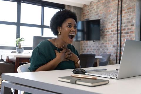 Excited African American Woman Engaging with Laptop in Office Setting