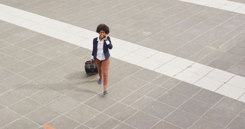 Businesswoman Walking with Luggage While Talking on Phone Outdoors - Download Free Stock Images Pikwizard.com
