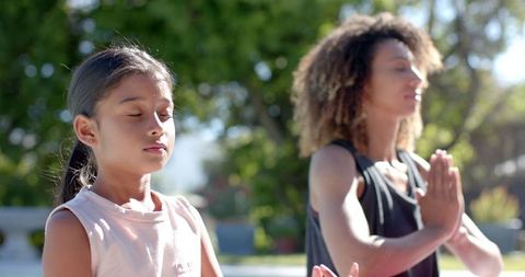 Mother and Daughter Meditating in Tranquil Garden Setting