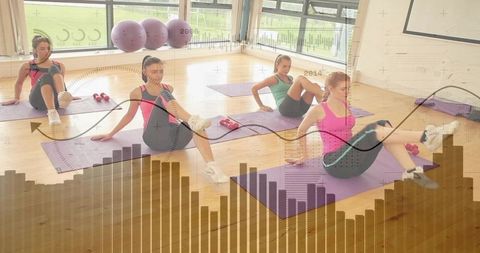 Women doing seated core with dumbbells on purple mats in sunlit studio