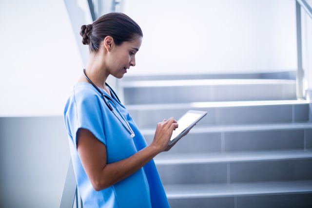 Female surgeon using digital tablet at hospital