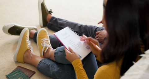 Couple planning vacation journey adventures with itinerary notebook