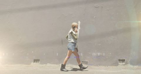 Young Woman Walking on City Street Using Smartphone