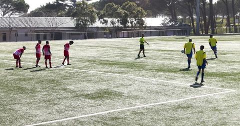 Youth Soccer Players Competing on Field Under Sunny Sky