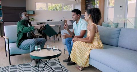 Couple discussing with advisor on couch for financial consultation