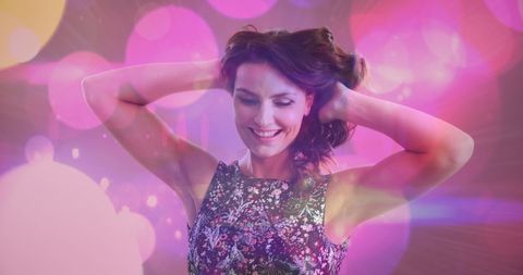 Joyful Woman Dancing in Vibrant Pink Party Lights