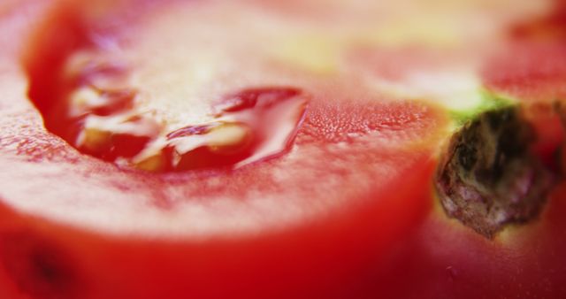 Close-up view of a ripe tomato slice, highlighting its juicy texture and vibrant red color. Its freshness and detail can evoke thoughts of healthy eating and the importance of including fresh produce in one's diet.