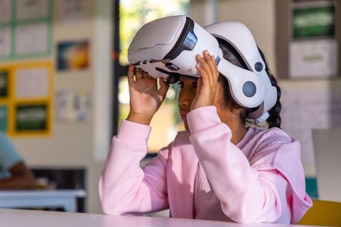 Schoolchild putting on vr headset in classroom hands-on virtual learning and stem exploration