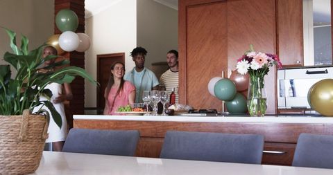 Friends Gathering in Modern Kitchen with Snacks and Drinks
