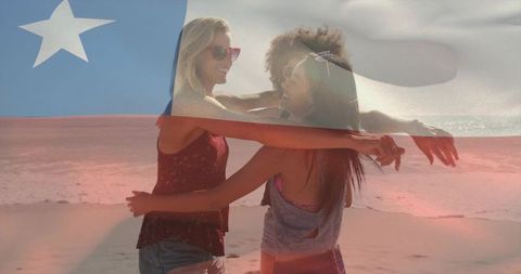 Friends hugging on sunny beach with flag overlay celebrating summer freedom