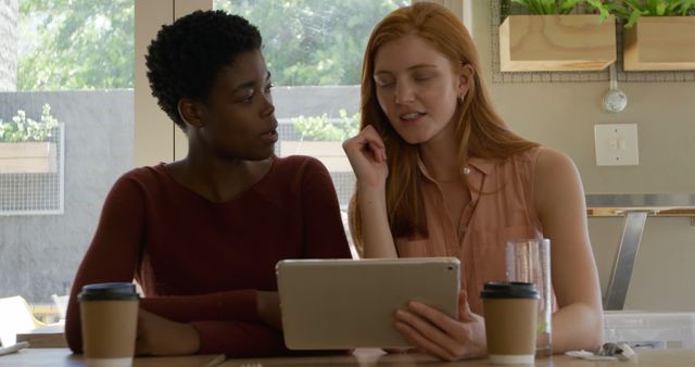 Two Women Connecting Over Tablet in Cozy Coffee Shop - Download Free Stock Images Pikwizard.com