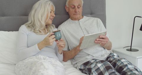 Senior Couple Enjoying Relaxed Morning with Coffee and Tablet