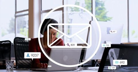 Businesswoman managing email notifications in modern office workspace