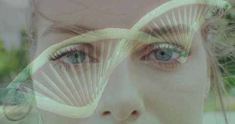 Translucent dna double helix overlaying close-up female face representing genetics and nature